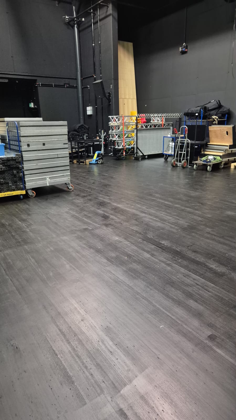 Abgenutzter schwarzer Bühnenboden im Backstage-Bereich der Stadthalle Gifhorn