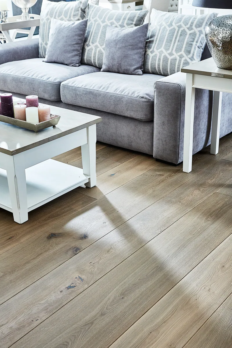 Graue Landhausdielen Dom-Betongrau der Dielenschmiede in einem Wohnzimmer mit hellem Sofa